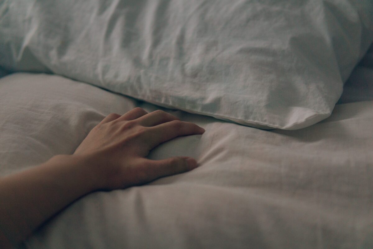 moody hand on bedsheets